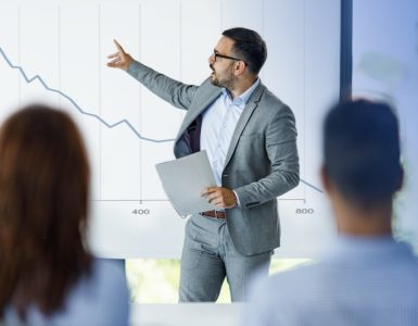 Man pointing to decreasing chart due to recession