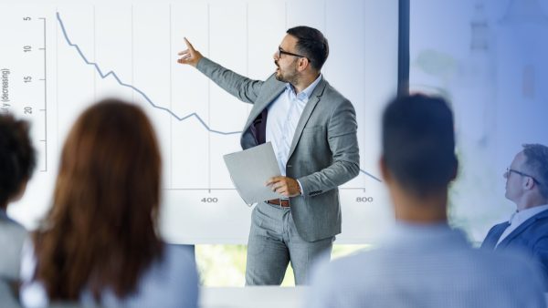 Man pointing to decreasing chart due to recession
