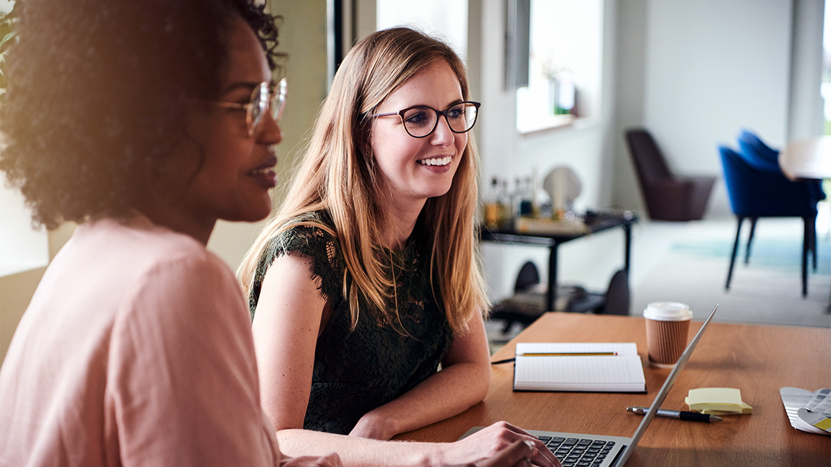 two women happily looking at a computer